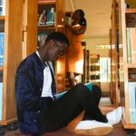 Jeune lecteur parmi des livres dans une bibliothèque