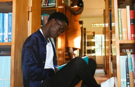 Jeune lecteur parmi des livres dans une bibliothèque