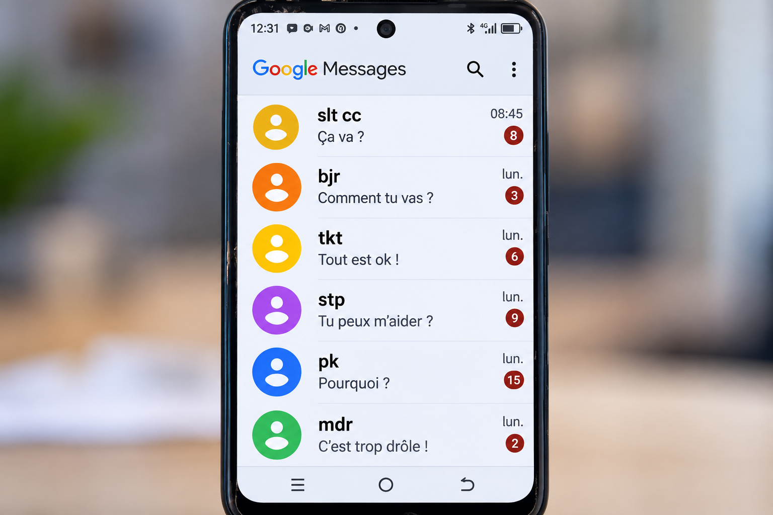 Téléphone affichant des exemples d’abréviations utilisées dans les messages, dont « slt cc », « bjr », « tkt », « stp », « pk » et « mdr »